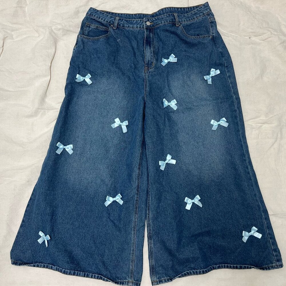 Wide leg blue jeans with powder blue bows scattered on front from CIDER